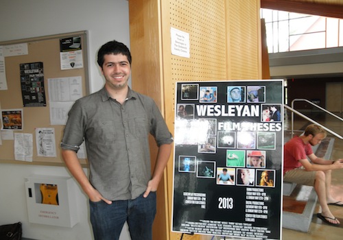 Senior Gabriel Urbina poses next to the Film Theses poster.